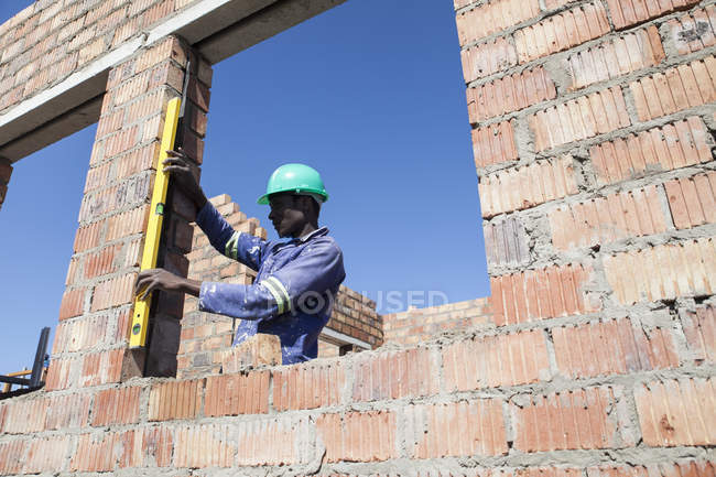 Constructor africano trabajando en obra - foto de stock