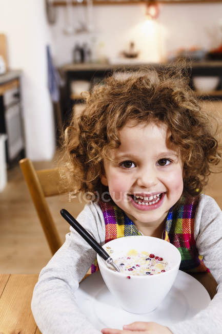Retrato de menina com sorriso de dente ter cereais na cozinha — Fotografia de Stock