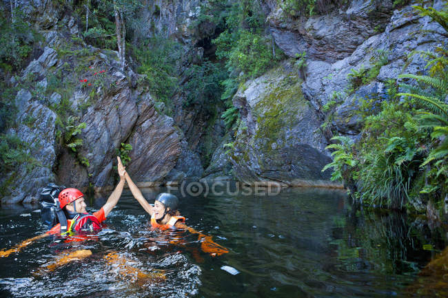 Чоловік і жінка дають п'ять під час плавання в басейні — стокове фото