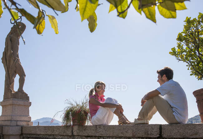 Coppia seduta sulla parete del giardino mediterraneo, Lago Maggiore, Italia — Foto stock