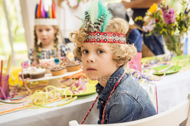 Portrait of serious looking boy at kids birthday party — Stock Photo