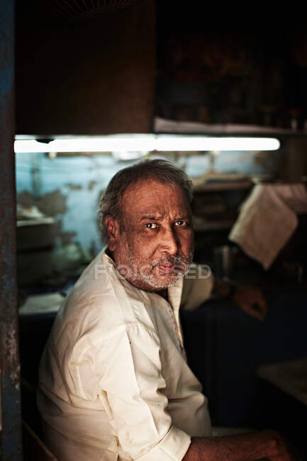 Homem de meia-idade sentado na loja — Fotografia de Stock
