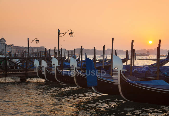 Barche a remi attraccate in porto durante il tramonto — Foto stock