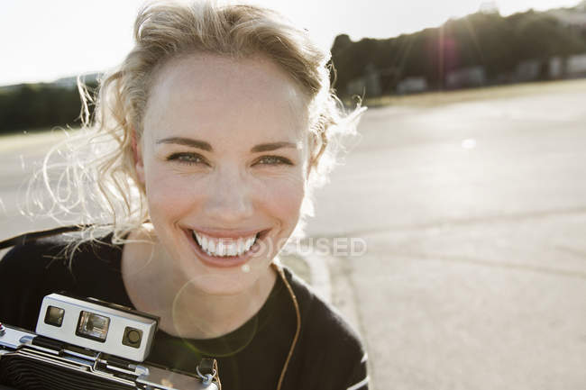 Portrait of happy mid adult woman with vintage camera — Stock Photo