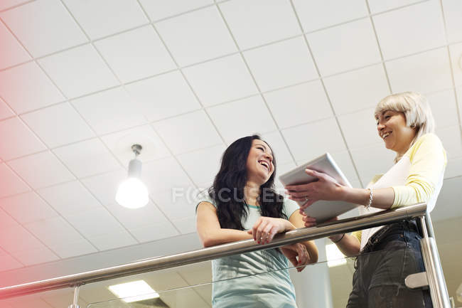 Young female students with digital tablet, low angle view — Stock Photo