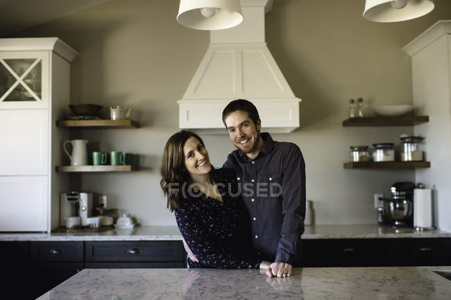 Retrato de casal adulto médio no balcão da cozinha — Fotografia de Stock