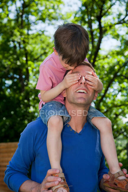 Child riding piggy back on father — Stock Photo