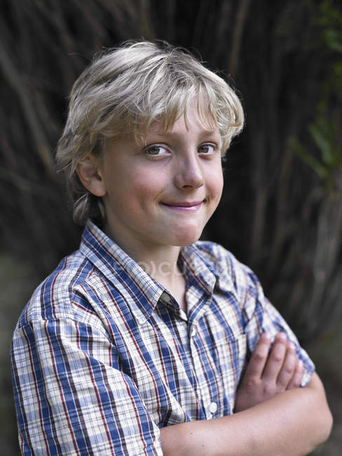 Портрет улыбающегося мальчика со сложенными руками — стоковое фото