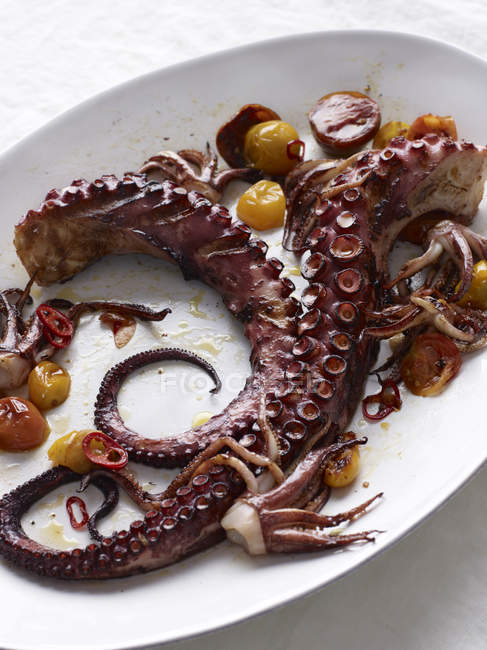 Octopus with roasted tomatoes and chilli peppers — Stock Photo