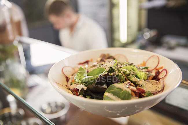 Bowl of salad on glass counter in restaurant — Stock Photo