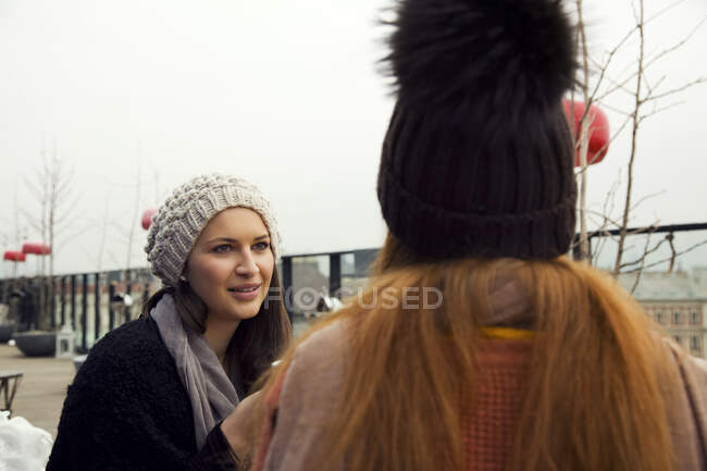 Two young adult women chatting on rooftop terrace — Stock Photo