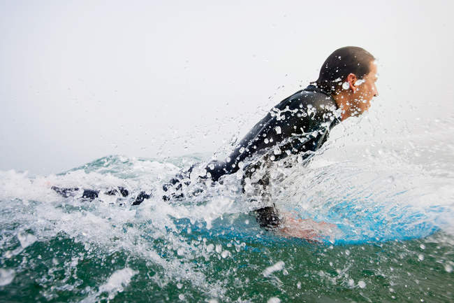 Hombre en traje de baño surfeando una ola oceánica, bahía boobys, cornwall, Inglaterra - foto de stock