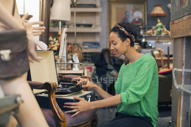 Young woman playing vinyl records in vintage shop — Stock Photo