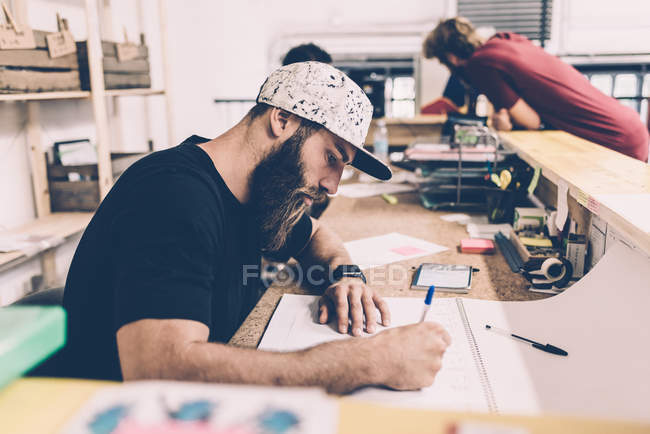 Young man writing on calendar at gym reception desk — Stock Photo