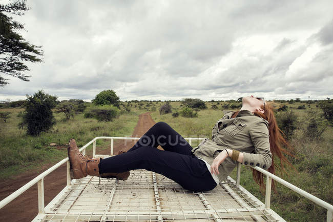 Woman enjoying ride on top of vehicle in wildlife park, Nairobi, Kenya — Stock Photo