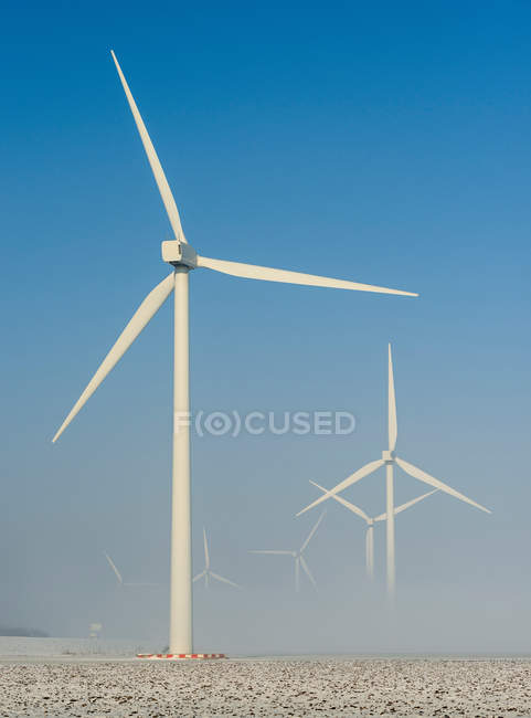 Turbine eoliche nel paesaggio innevato con cielo blu — Foto stock