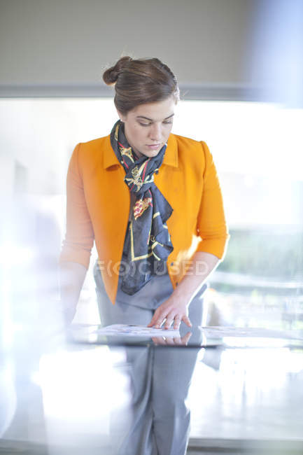 Femme d'affaires regardant la paperasse sur le bureau — Photo de stock