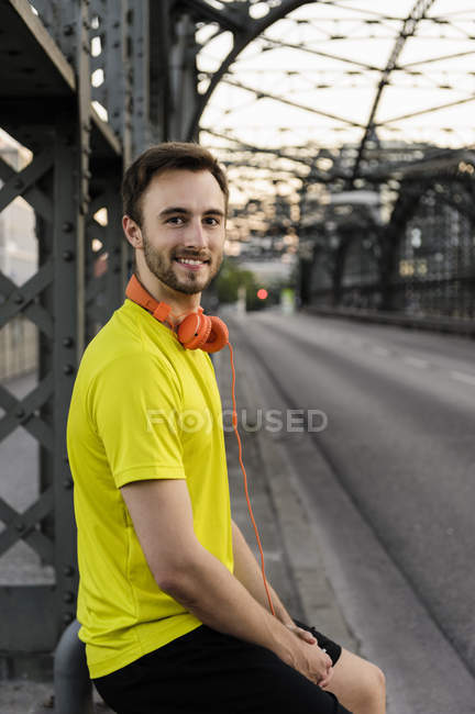 Porträt eines jungen männlichen Läufers, der auf Brücke Pause macht — Stockfoto