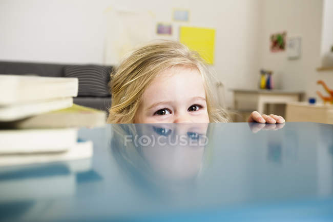 Дівчина заглядає над столом — стокове фото