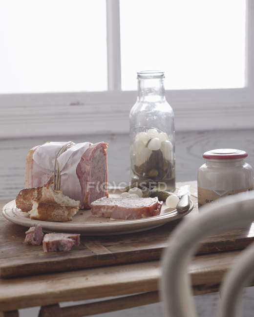 Schweineterrine in Scheiben geschnitten mit Essiggurken auf Teller — Stockfoto