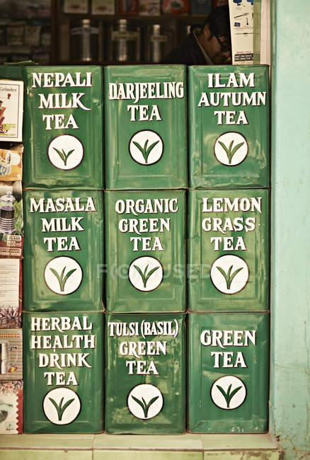 Latas de té verde apiladas en la puerta de la tienda, Katmandú, Nepal - foto de stock
