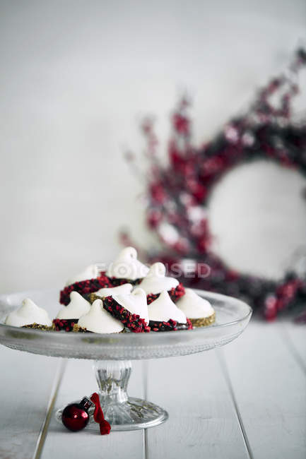Christmas bauble decoration and meringues on cakestand — Stock Photo