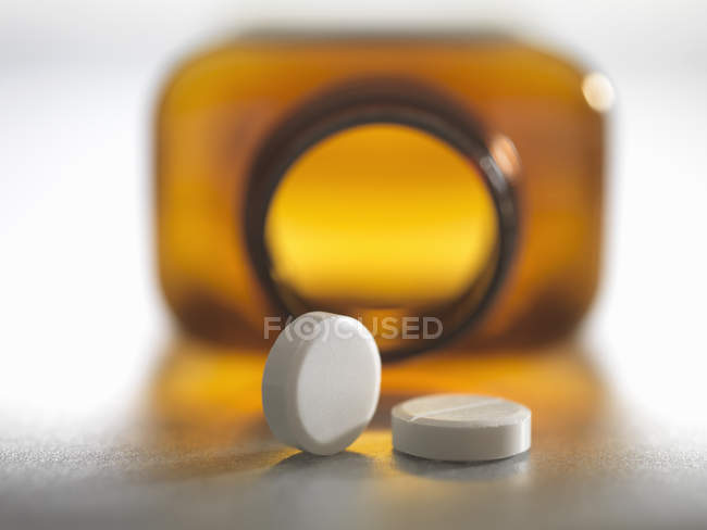 Pain killers pouring from brown medicine bottle — Stock Photo