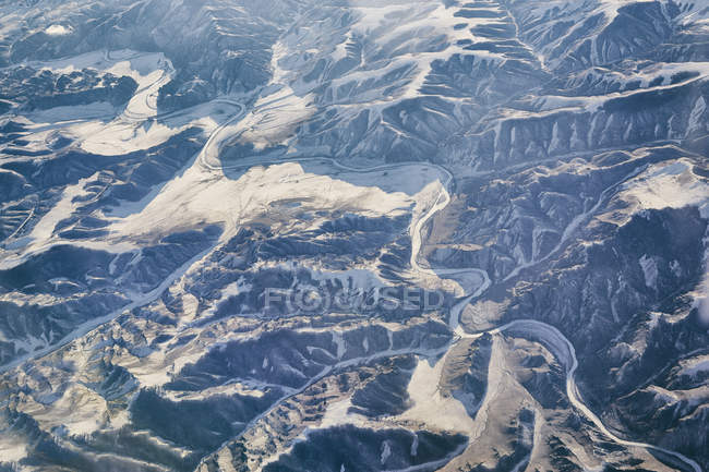 Aerial view of snowcapped mountain range in sunlight — Stock Photo