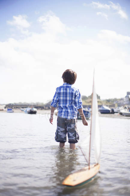 Портрет мальчика, играющего с моделью лодки — стоковое фото