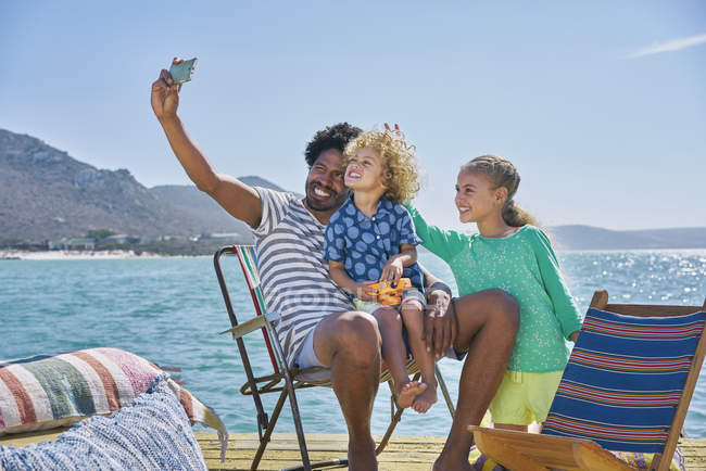 Familia tomando selfie en cubierta de la casa flotante, Kraalbaai, Sudáfrica - foto de stock