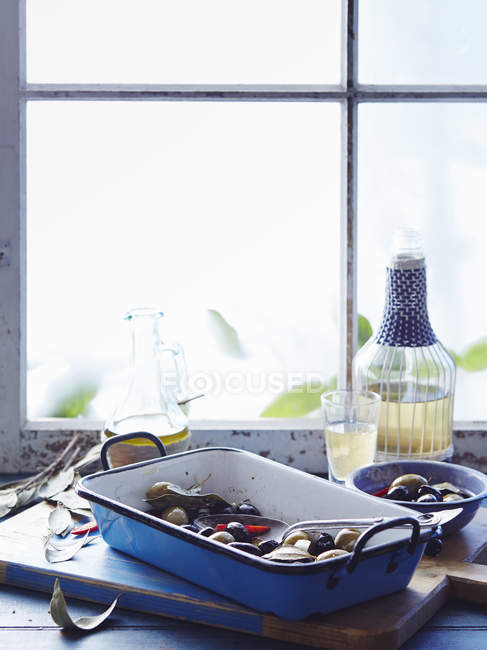 Смачні оливки з перцем чилі в мисках на обробній дошці — стокове фото