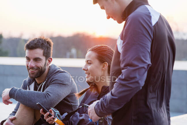 Groupe d'amis, portant des vêtements de sport, bavardant, en plein air — Photo de stock