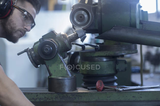 Caucasian adult man working in grinding workshop — Stock Photo