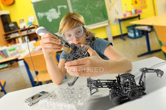 Junge mit digitalem Stift und 3D-Modell eines Baggers im Klassenzimmer — Stockfoto