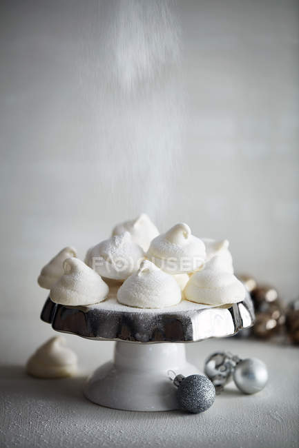 Meringues on cake stand and Christmas baubles — Stock Photo