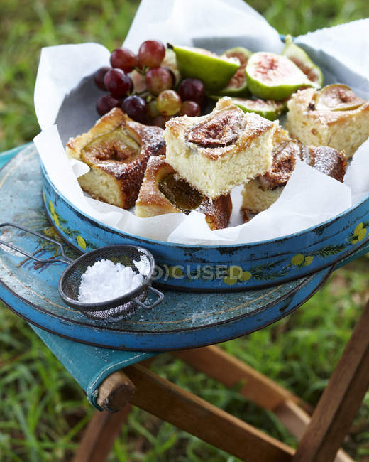 Coconut cake with figs and grapes in cake tin — Stock Photo