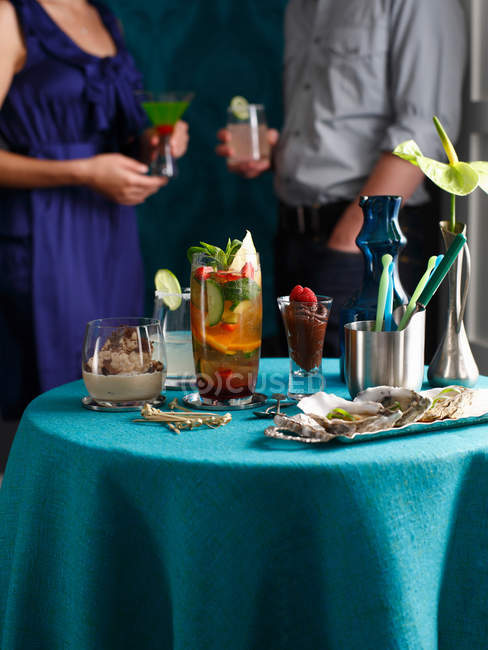 Table with oysters, cocktail drinks and desserts at party — Stock Photo
