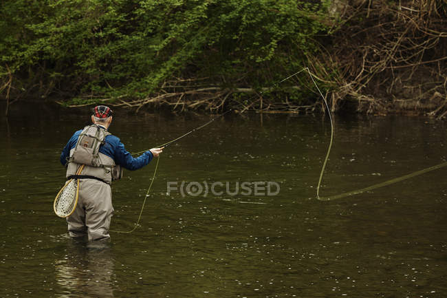 Hombre pescando en el río - foto de stock