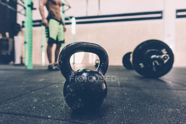 Kettlebell and barbell on floor of cross training gym — Stock Photo