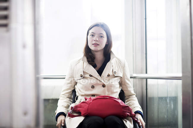 Portrait of young woman using wheelchair in elevator — Stock Photo