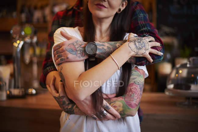 Cropped view of tattooed couple hugging — Stock Photo