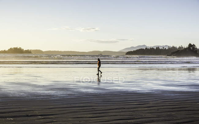 Homem passeando em Long Beach ao nascer do sol, Pacific Rim National Park, Vancouver Island, British Columbia, Canadá — Fotografia de Stock