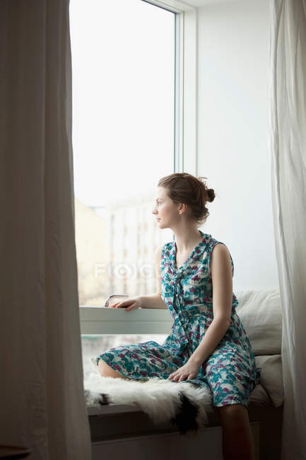 Frau schaut aus dem Fenster — Stockfoto