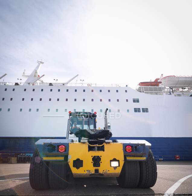 Transporte de contenedores camión y conductor con barco en puerto - foto de stock