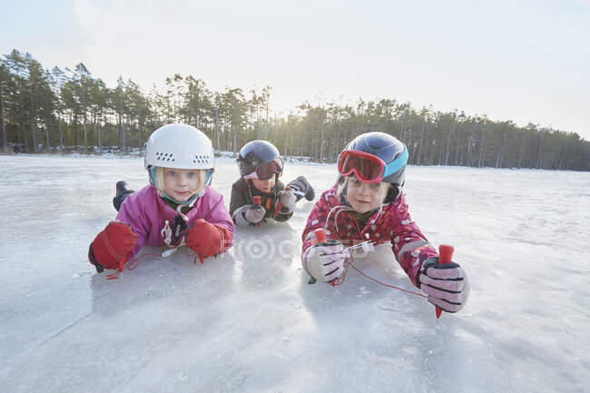 Porträt von Mädchen und Jungen, die auf einem zugefrorenen See kriechen, Gavle, Schweden — Stockfoto