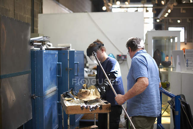 Glassblowers in workshop wearing protective gloves forming glass — Stock Photo