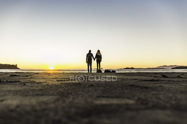 Coppia che guarda il tramonto da Long Beach, Pacific Rim National Park, Vancouver Island, British Columbia, Canada — Foto stock