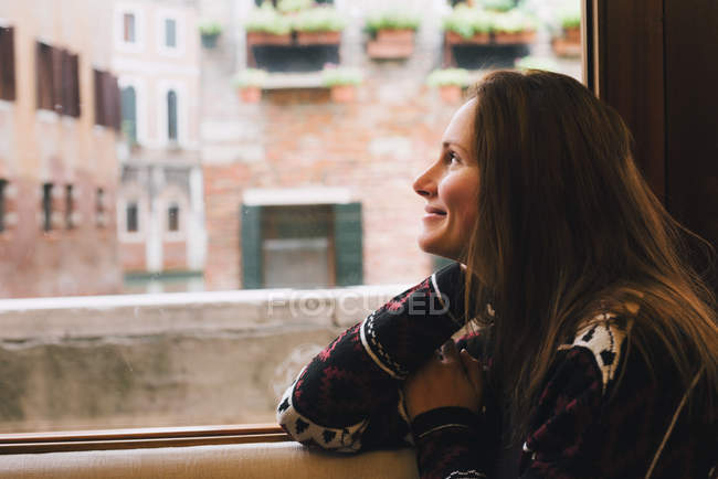 Donna che guarda fuori dalla finestra, Venezia, Italia — Foto stock