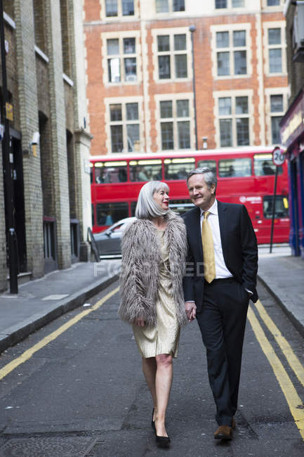 Couple habillé et dehors marchant dans la rue — Photo de stock