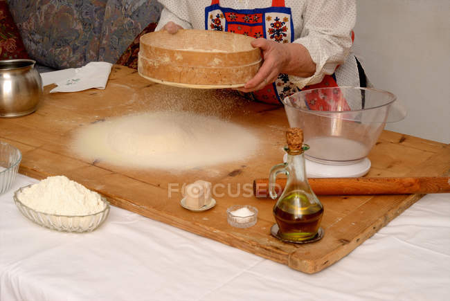 Cropped image of senior woman baking in living room — Stock Photo